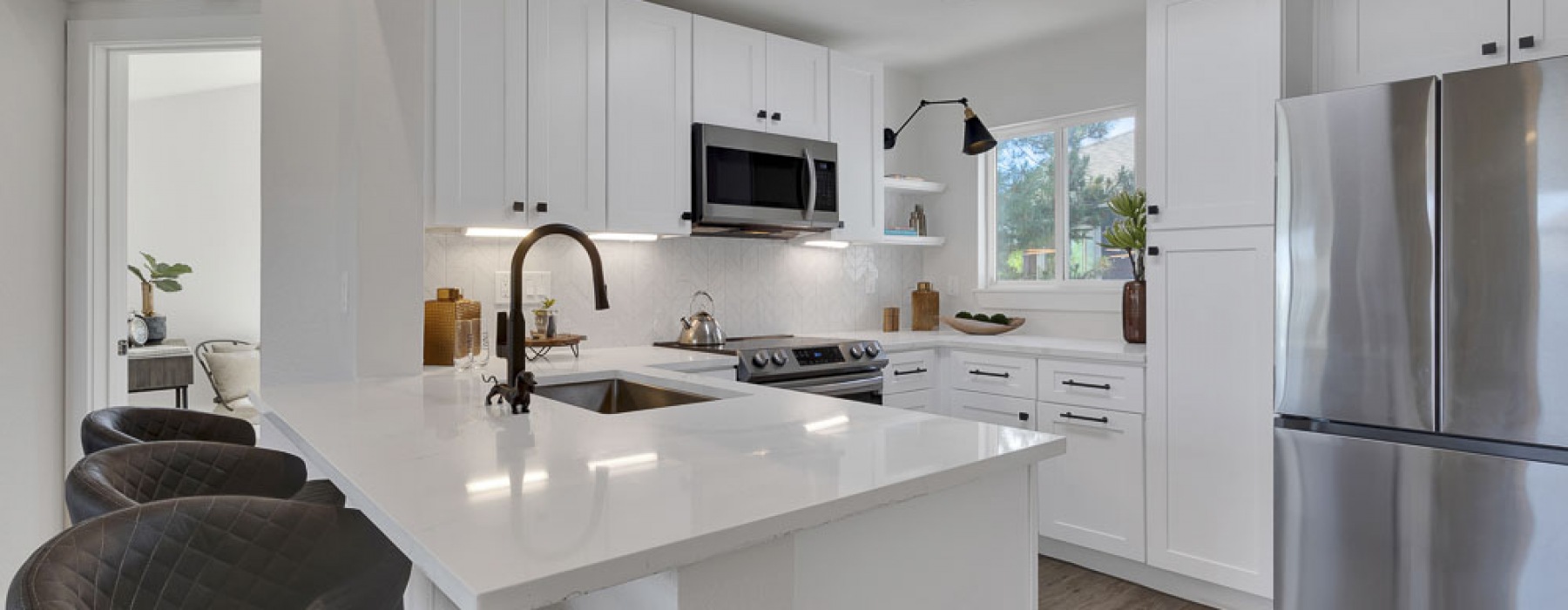 Kitchen with white counters and cabinets, stainless steel appliances